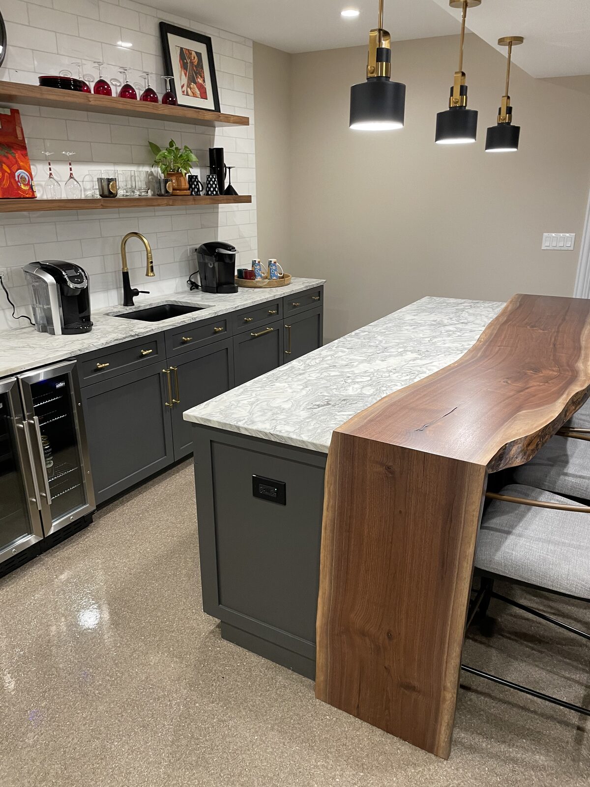 Live-edge walnut waterfall bar top with charcoal painted cabinetry and marble backsplash