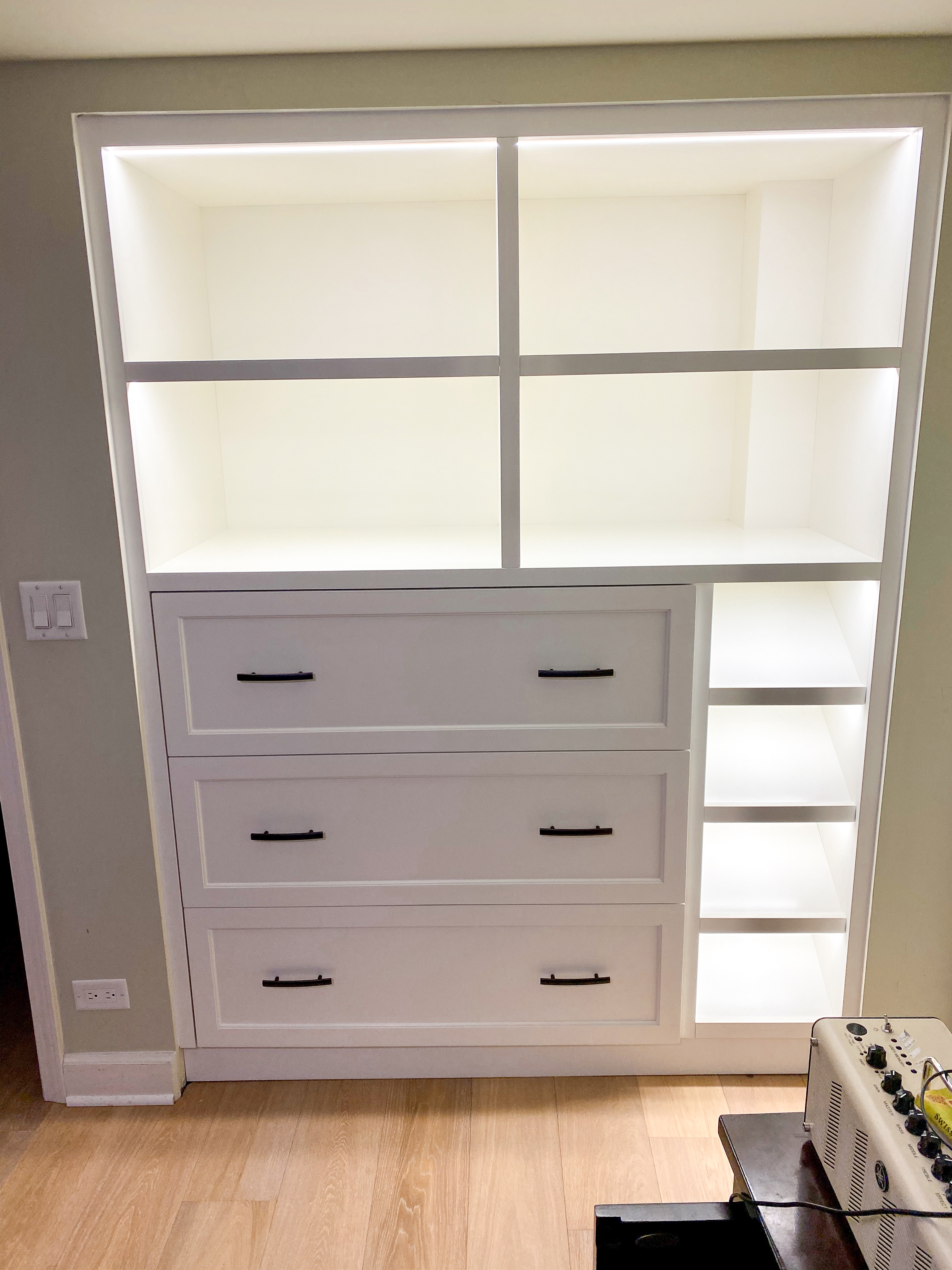 White painted built-in with open upper cubbies and center drawer bank