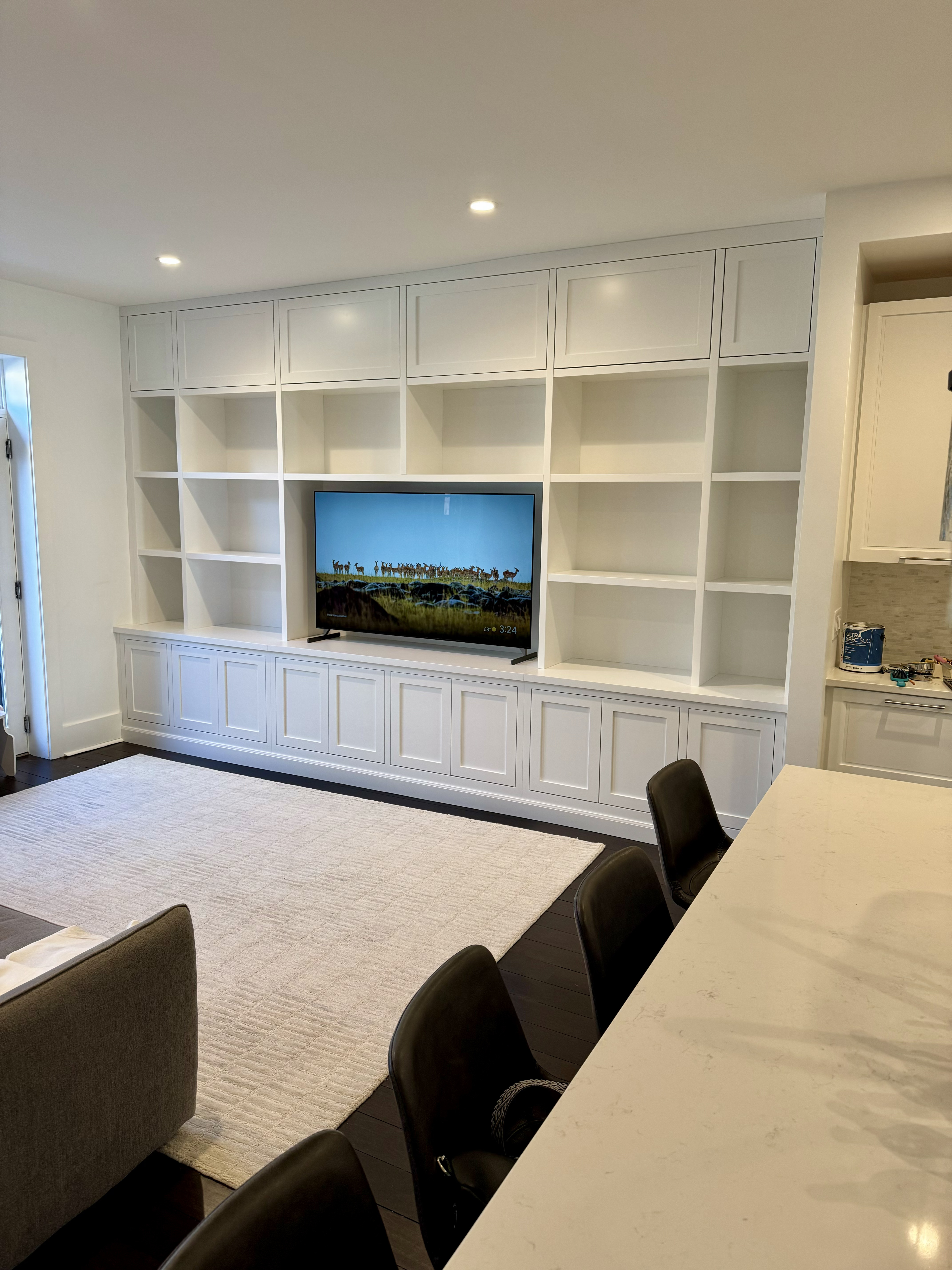 Large white painted entertainment wall unit with open shelving bays and TV niche