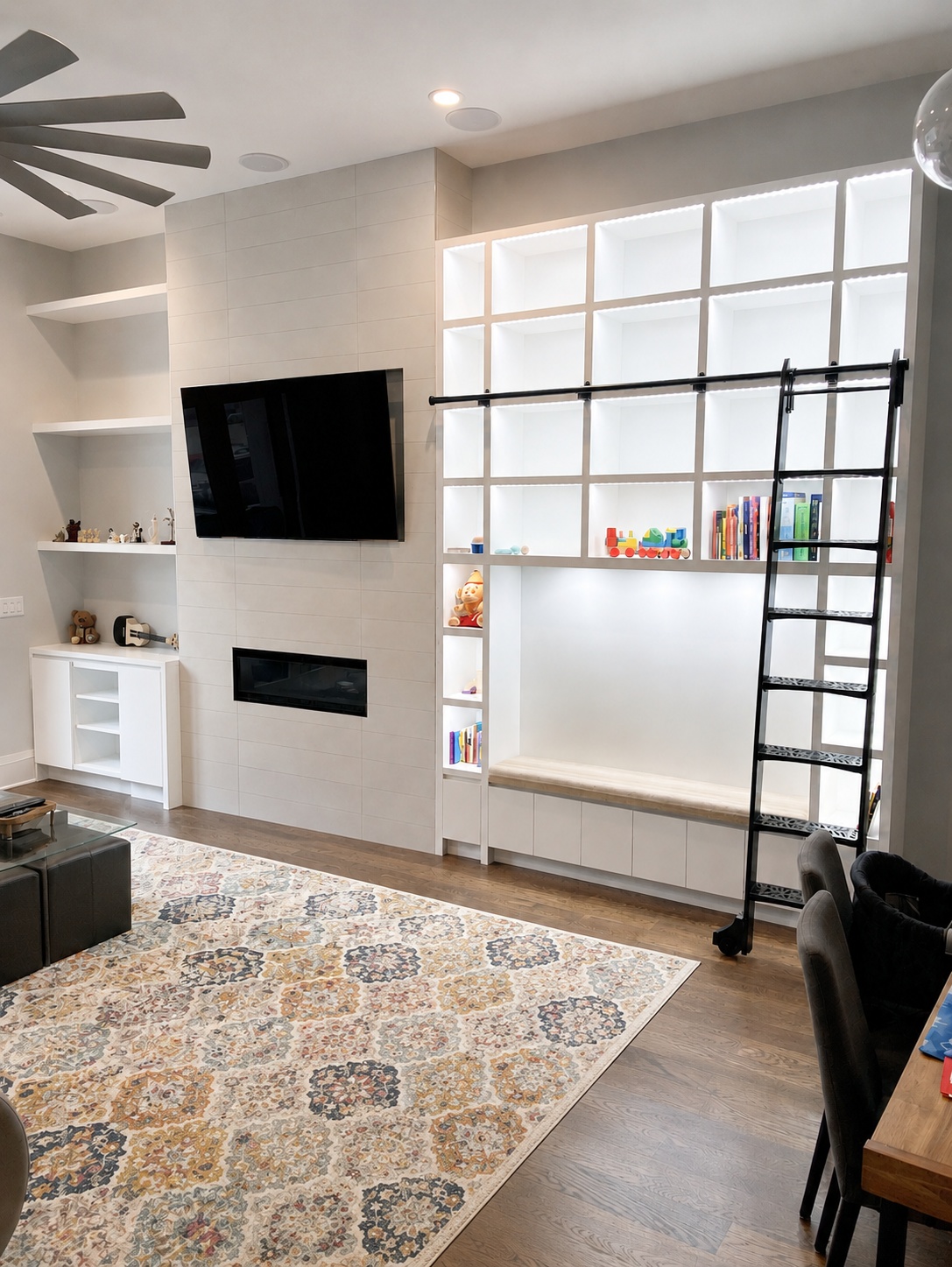 White painted library wall unit with open grid cubbies, rolling library ladder, linear fireplace, and built-in bench