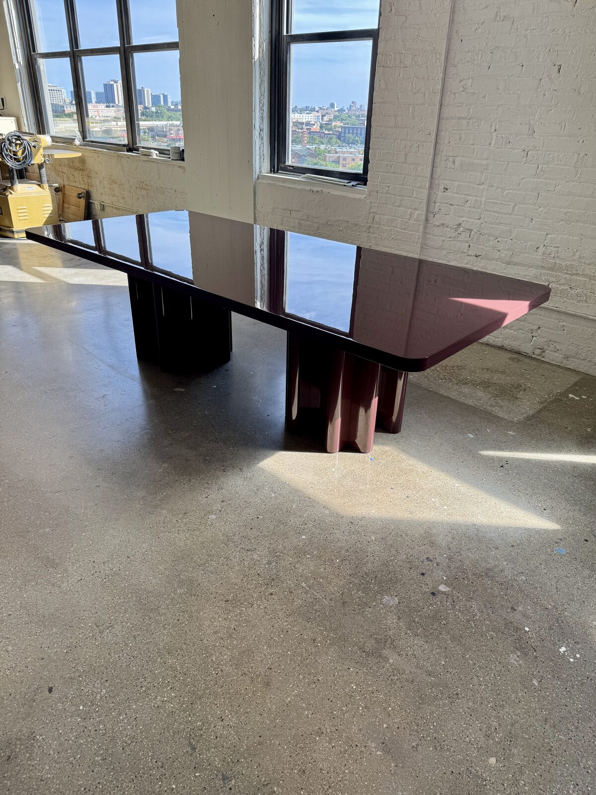 High-gloss aubergine lacquer dining table reflecting the Chicago skyline