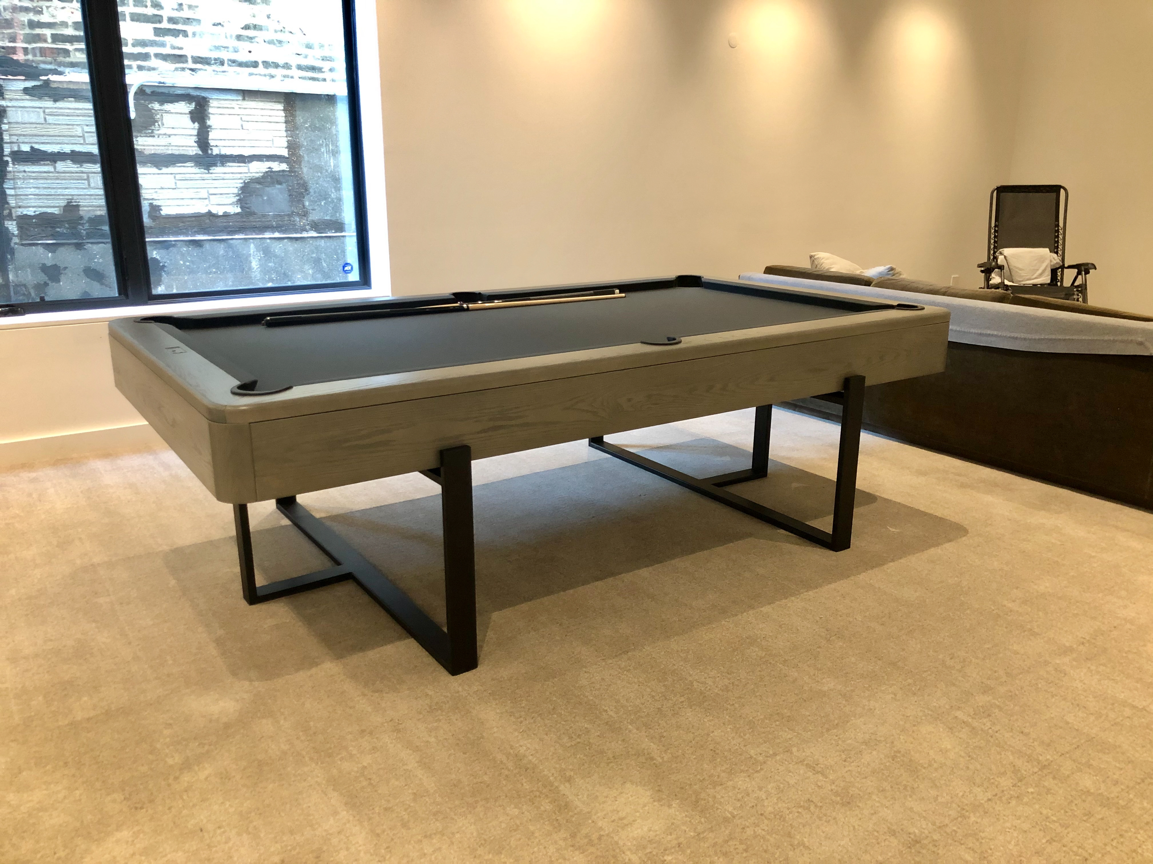 Custom pool table with light ash wood frame and black steel base legs