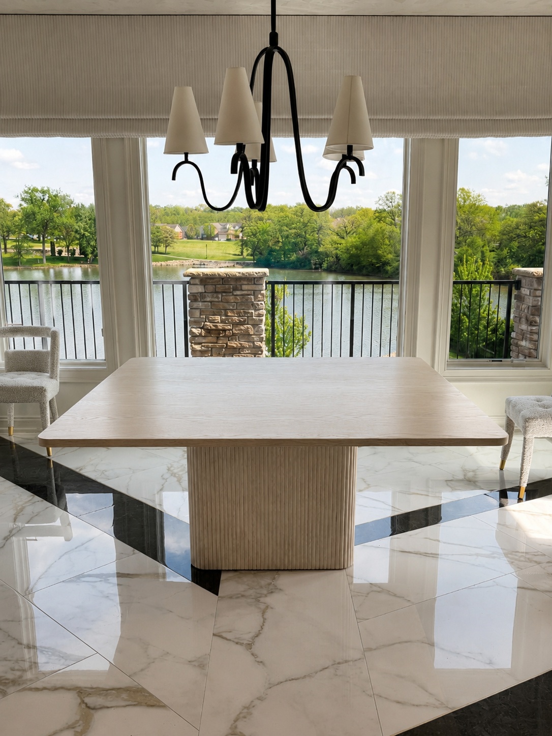 Limed oak square dining table on fluted pedestal with marble tile floor and lake view beyond
