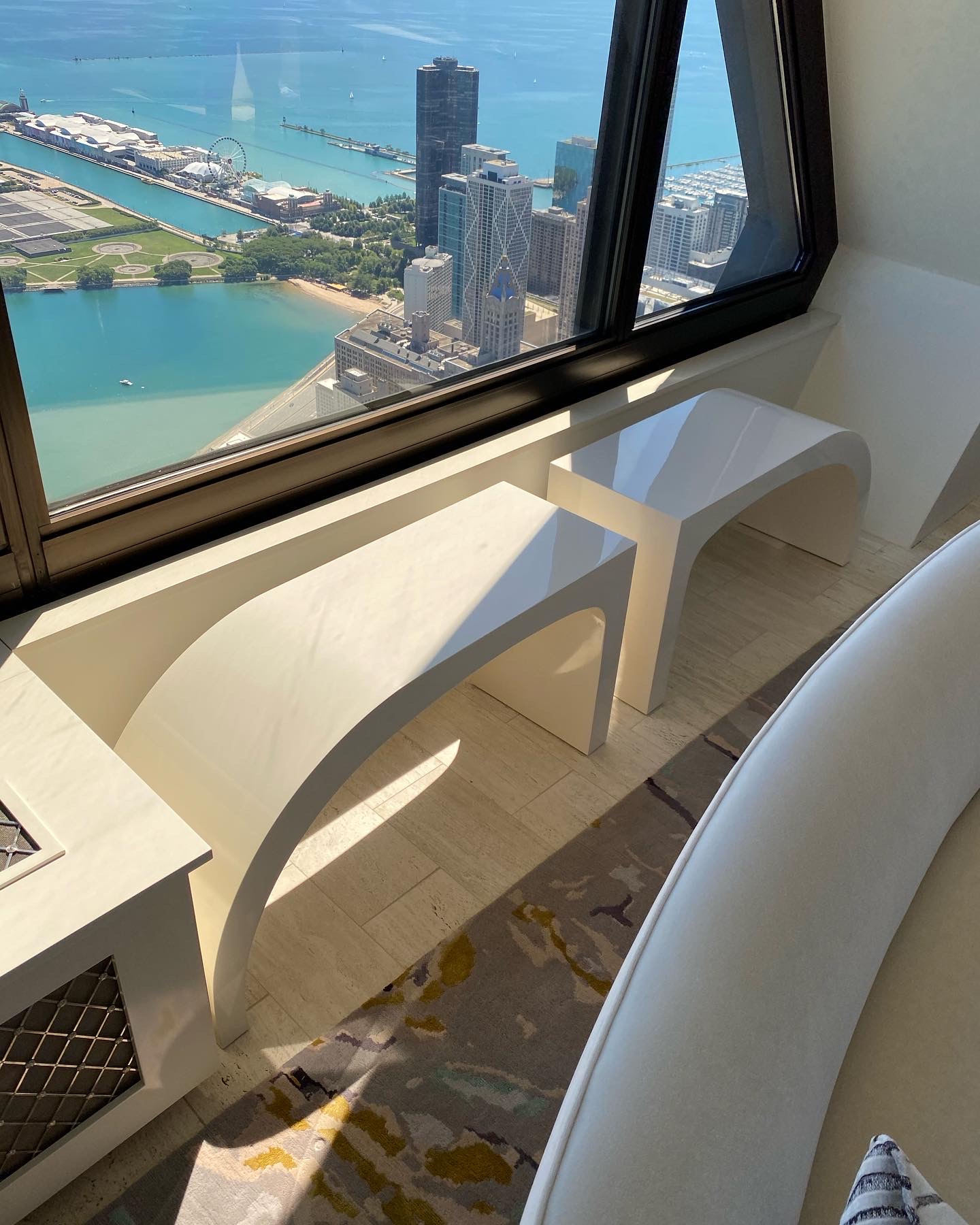Custom white lacquer console with arched openings photographed in a Chicago high-rise with lake and Navy Pier views