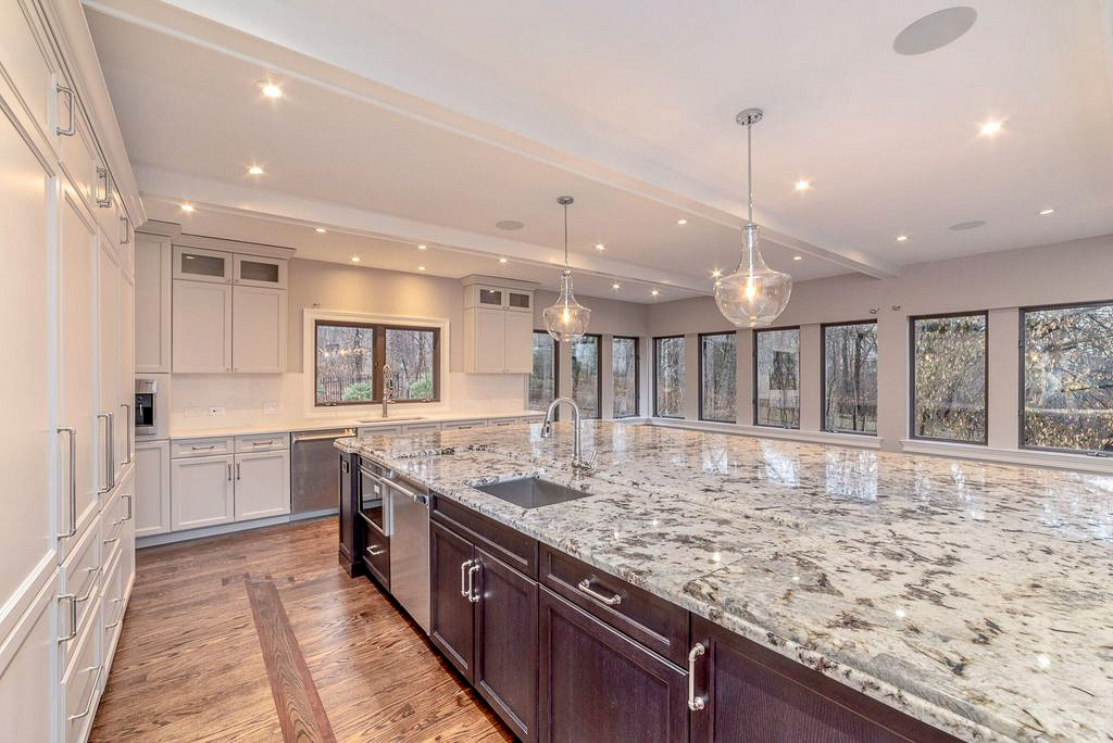 Espresso stained island kitchen with white granite countertop and garden window