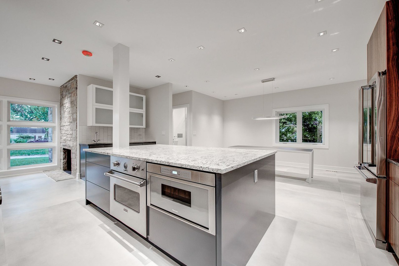 Walnut island kitchen with Thermador appliances and polished concrete floors