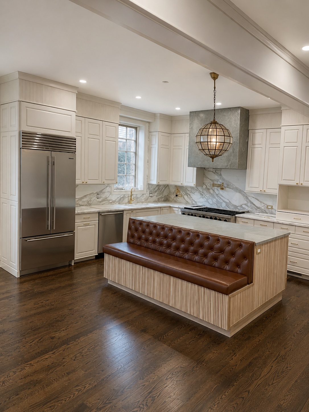 White painted traditional kitchen with SubZero refrigerator, tufted leather banquette island, and zinc range hood