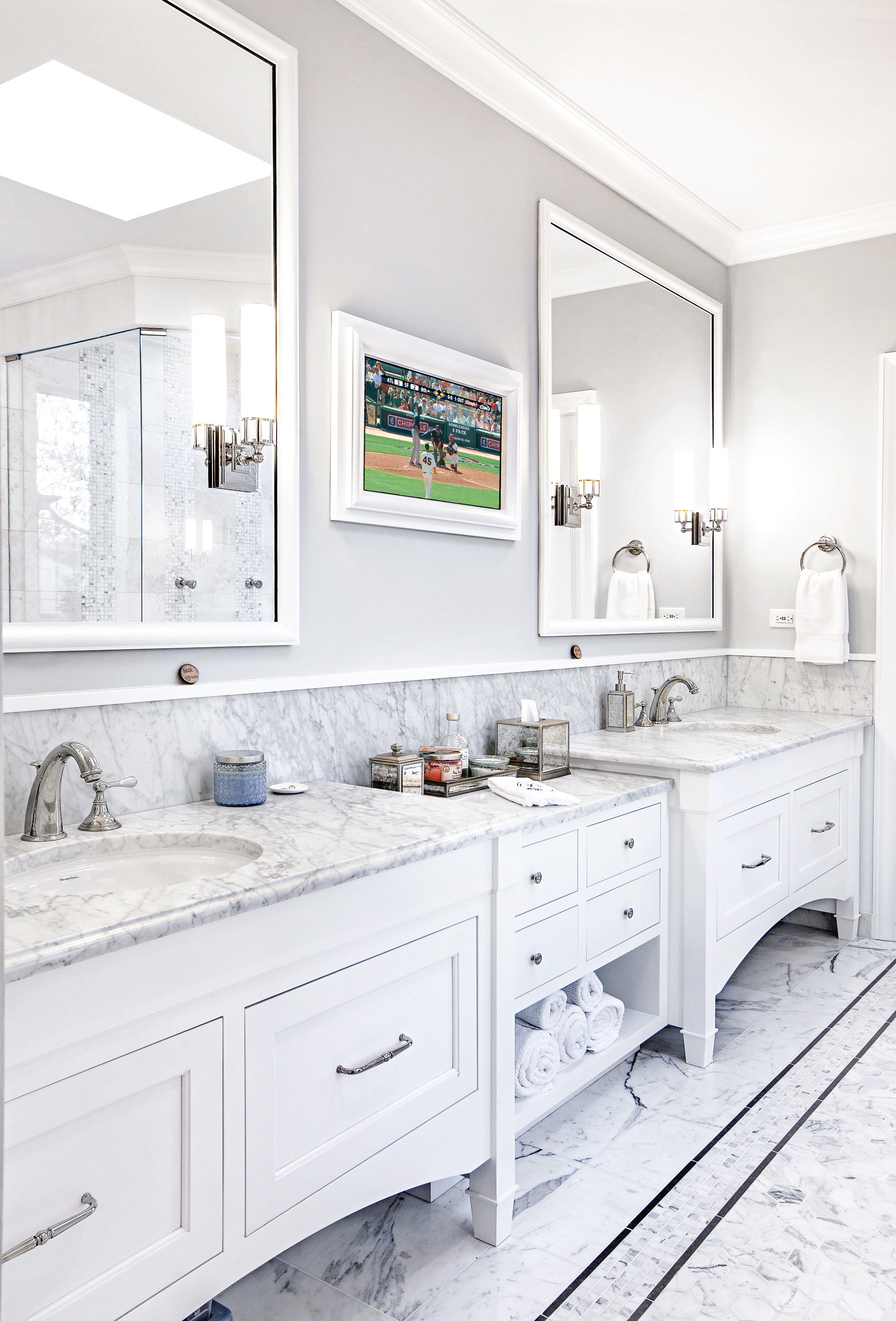 Double-sink white painted vanity with Calacatta marble countertop and TV mirror above